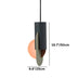 Black cylindrical pendant light with peach sphere and taupe accent on white background.