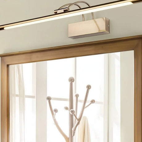 "A modern, silver LED wall lamp illuminating a hallway mirror."
