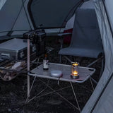 Orena Table Lamp - Sleek Rechargeable Indoor/Outdoor Light in black, used as a cozy light source inside a camping tent setup.