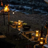 Orena Table Lamp - Sleek Rechargeable Indoor/Outdoor Light illuminating a campsite dinner table with warm ambient lighting by the river.
