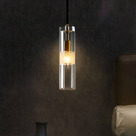 "A modern pendant light with a clear textured glass shade hanging over a bedside table."