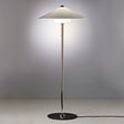 "Oriel floor lamp with a sleek metallic frame, wide conical fabric shade, made from aluminum, iron, and fabric, providing soft, diffused lighting in modern interiors."