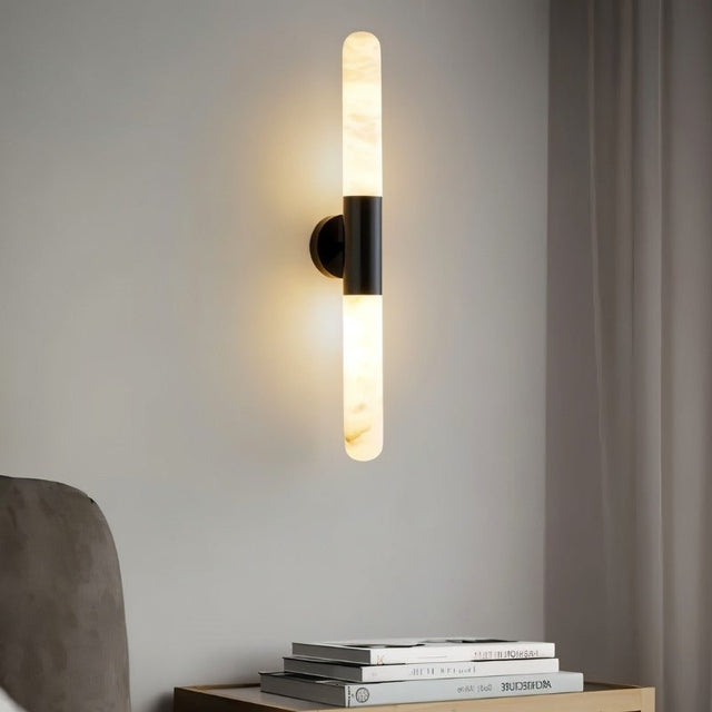 "Modern alabaster wall lamp with a black metallic center, illuminating a contemporary bedroom."