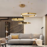 "A modern, geometric chandelier with interconnected gold frames illuminates a stylish apartment living room."