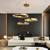 "A modern, gold geometric chandelier enhances the interior design of a contemporary living room."
