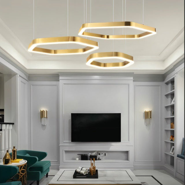 "A modern, geometric chandelier with interconnected gold hexagons illuminates a contemporary living room with a television."