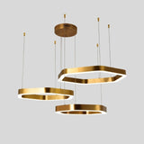 "Gold stainless steel chandelier with three tiered hexagonal frames and integrated LED lighting, suspended against a light grey background."