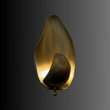 "Lit copper wall lamp with a leaf-inspired design casting a warm glow, isolated on a dark background."