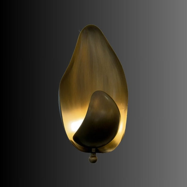 "Lit copper wall lamp with a leaf-inspired design casting a warm glow, isolated on a dark background."