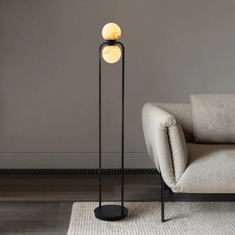 "Minimalist floor lamp with a sleek aluminum frame and alabaster globe, adding modern elegance to a contemporary living room setting."