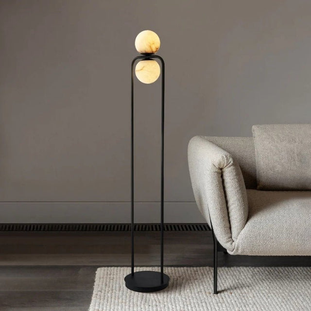 "Minimalist floor lamp with a sleek aluminum frame and alabaster globe, adding modern elegance to a contemporary living room setting."