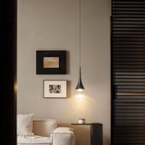 Black Osvet Pendant Light illuminating a cozy living room corner with modern decor and neutral tones.