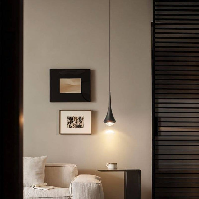 Black Osvet Pendant Light illuminating a cozy living room corner with modern decor and neutral tones.