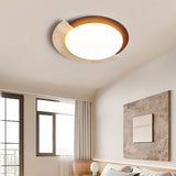 "Wabi-sabi flush mount light with travertine and white diffuser on a bedroom ceiling, providing soft ambient light above a bed with a textured throw and a framed art piece on the wall."