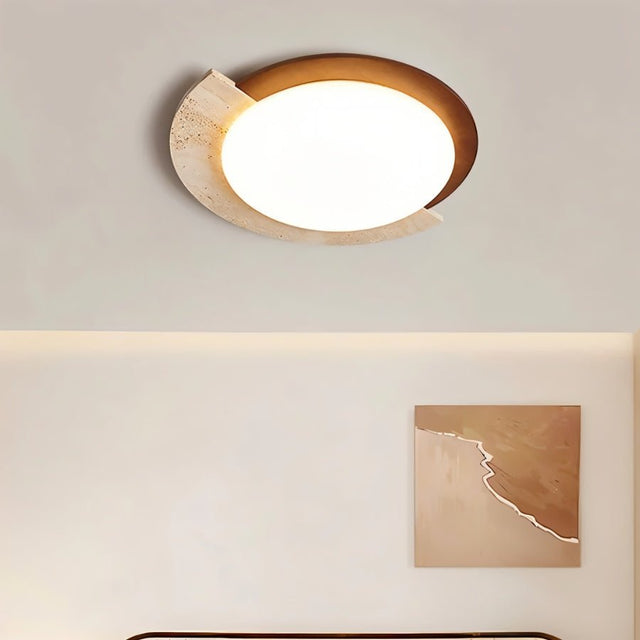 "Wabi-sabi flush mount light with travertine and white diffuser, mounted on a light-colored wall, serving as a wall lamp above a bed."