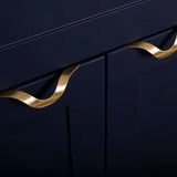 "Two brass drawer pulls with an elegant, wavy design mounted on a navy blue cabinet, adding a luxurious touch to a modern kitchen."