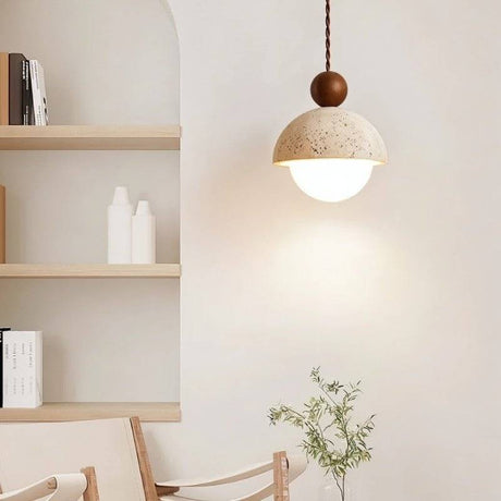 "A Palermo pendant light, made of yellow travertine with a walnut wood accent, hangs in a modern living room, providing warm, ambient light."