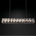 Linear chandelier with polished nickel frame and crystal prisms suspended by chains against a dark background.