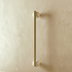Gold pull bar with white marble rosettes mounted on gray cabinet doors.