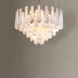 Alabaster chandelier with white teardrop-shaped panels and brass hardware suspended against a gray background.