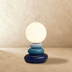 Stacked ring-shaped white ceramic candleholder with spherical top, shown against white background.
