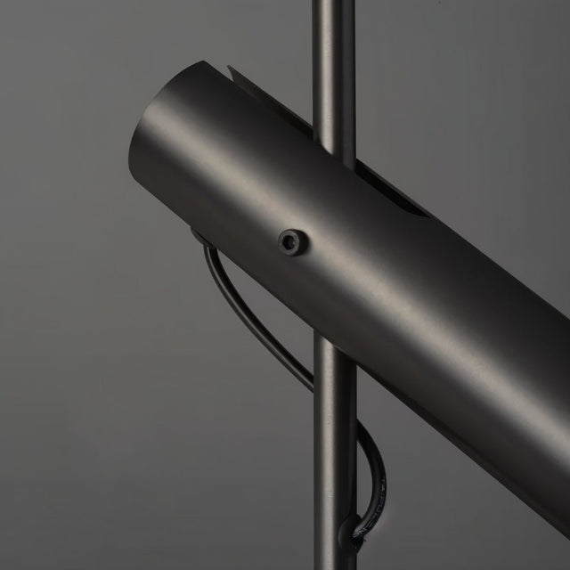 "Close-up of a modern black stainless steel pendant light with adjustable tube detail."