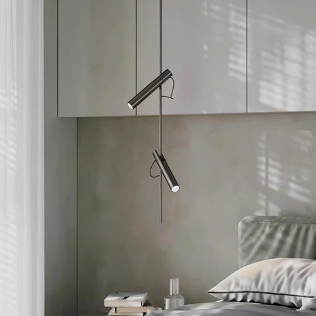 "A modern black stainless steel pendant light with adjustable tubes in a bedroom with gray furniture."