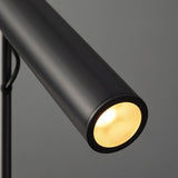 "Close-up of a modern black stainless steel pendant light with a lit cylindrical tube."