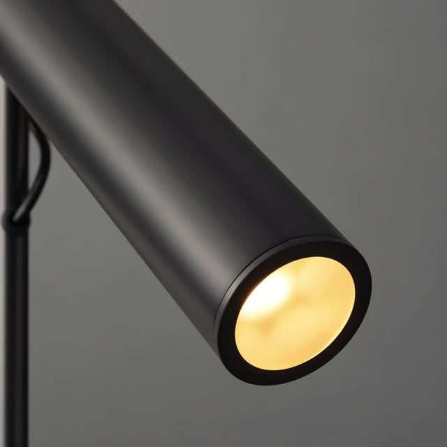 "Close-up of a modern black stainless steel pendant light with a lit cylindrical tube."