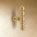 Brass Perla beaded knob with stacked spheres and side orbs on a cream textured wall