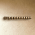 Vintage brass Perla beaded pull bar with aligned spheres on a cream textured wall