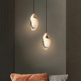 "Pair of modern pendant lights with fluid crystal forms and metal tops in a contemporary living room."