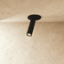 Black cylindrical ceiling light fixtures mounted on white ceiling in modern apartment interior