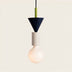 Pixie Pendant Light features a navy cone top, cream cylindrical midsection, and a soft glowing bulb against a plain white bac