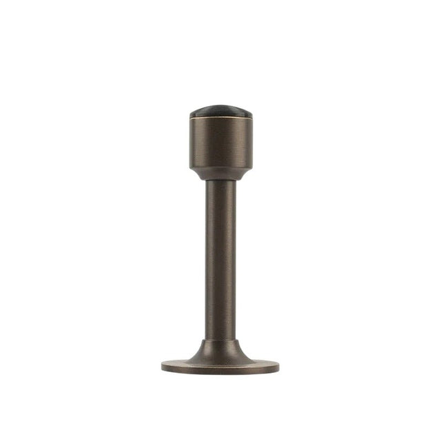 "Sculpted brass door stop with a sleek, tapered silhouette, gunmetal polished finish, wide stable base, and magnetic hold, designed to prevent wall damage."