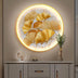 Illuminated round art featuring golden ginkgo leaves against a plain white background, enhancing a stylish interior setting.