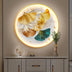 Illuminated wall art featuring golden and teal ginkgo leaves on a beige wall, enhancing a modern interior scene.