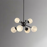 "Starburst chandelier with iron arms and textured acrylic diffusers, featuring six lights against a gray background."