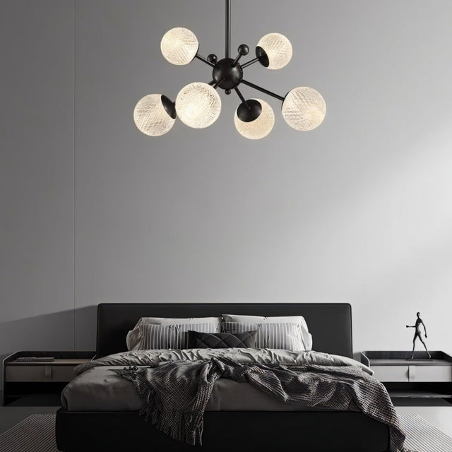 "Starburst chandelier with iron arms and textured acrylic diffusers, hanging above a contemporary bed."