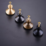 "Dome-shaped brass cabinet knobs with flared bases and visible screws, showcasing their construction and design."