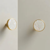 "Brass knobs with pearl shell inlays, adding a touch of modern elegance to cabinet doors."