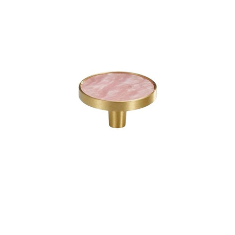 "Top view of a round brass cabinet knob with a pink shell inlay, isolated on a white background."
