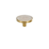 "Flat lay of a round brass cabinet knob with a white shell inlay, isolated on a white background."