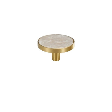 "Flat lay of a round brass cabinet knob with a white shell inlay, isolated on a white background."