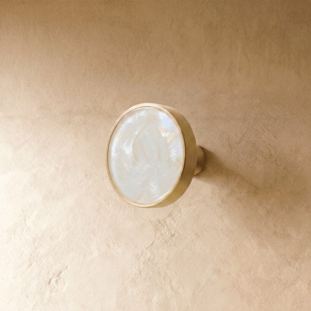 "Modern luxury brass knobs and pull bars with shell inlays, featuring pearl and abstract textures for contemporary interiors."