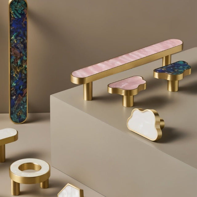 "Modern luxury brass knobs and pull bars with shell inlays, featuring pearl and abstract textures for contemporary interiors."