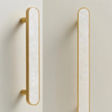 "Modern white shell inlay pull bars with brass frames, adding a touch of elegance to contemporary cabinets and drawers."