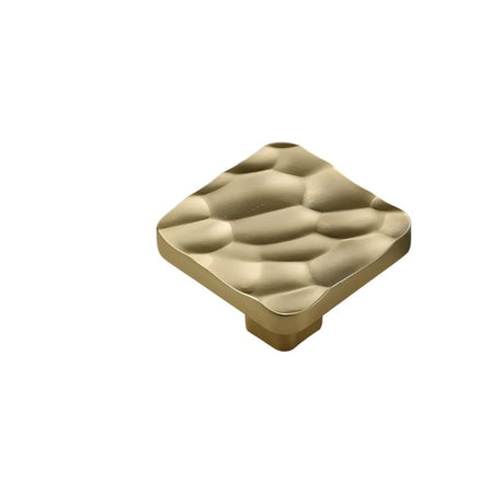 "Gold hammered texture square cabinet knob isolated on a white background, showcasing its modern and artisanal design."
