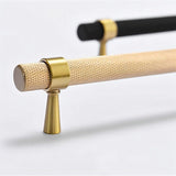 "Close-up of precision-crafted brass knurled pull bar handles in black and gold finishes, highlighting the textured grip and sleek metallic look."