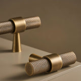 "Precision-crafted brass knurled pull bar handles with a cylindrical shape and sleek metallic finish."
